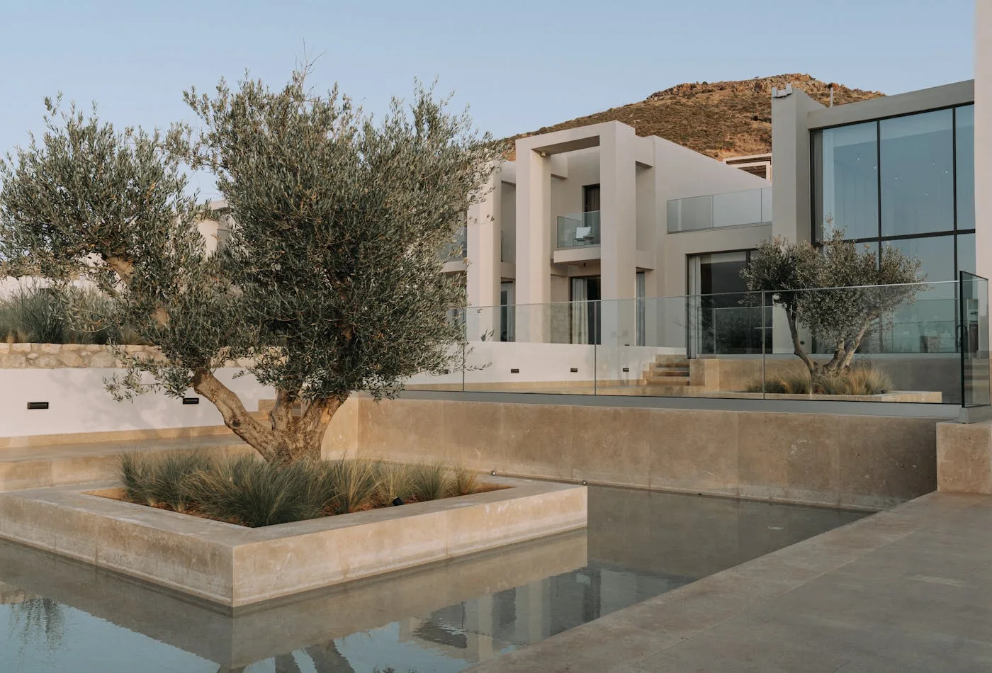 A modern home exterior with clean cladding, large windows, and landscaping