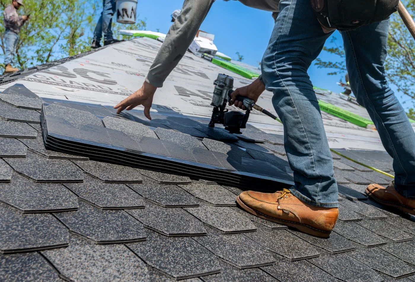 Roofers installing shingles on a residential roof